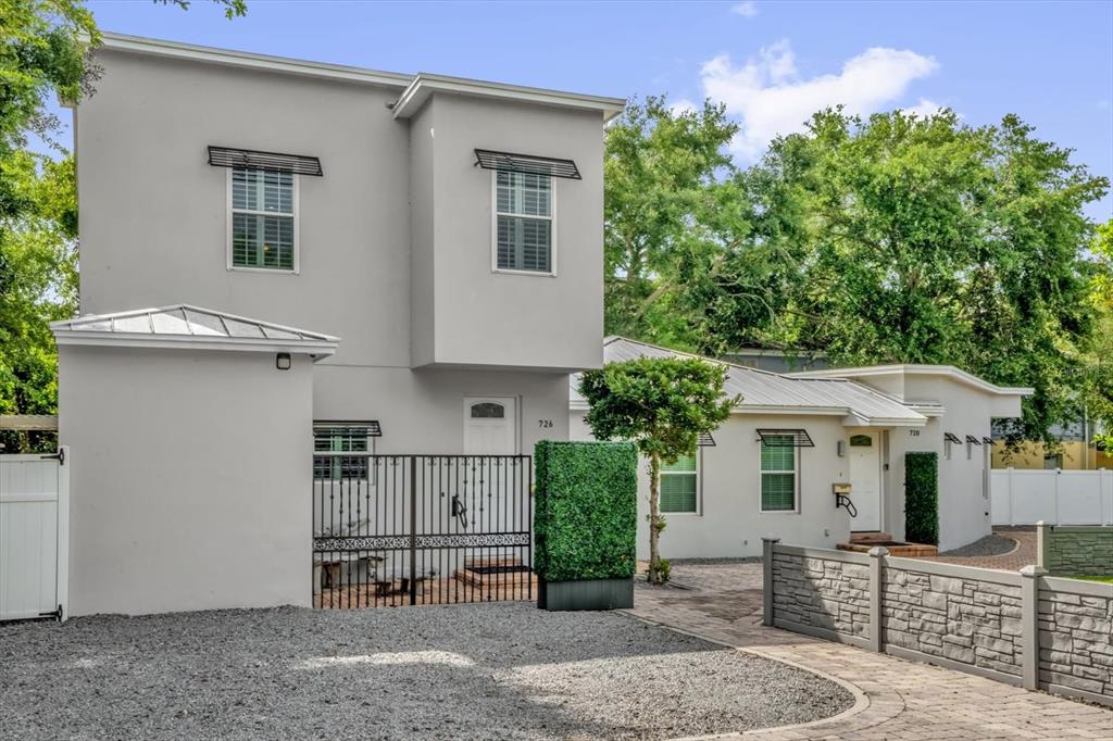 A two-story gray stucco house with a gravel driveway and a metal gate — 726/720 N PENNSYLVANIA AVENUE, WINTER PARK, FL