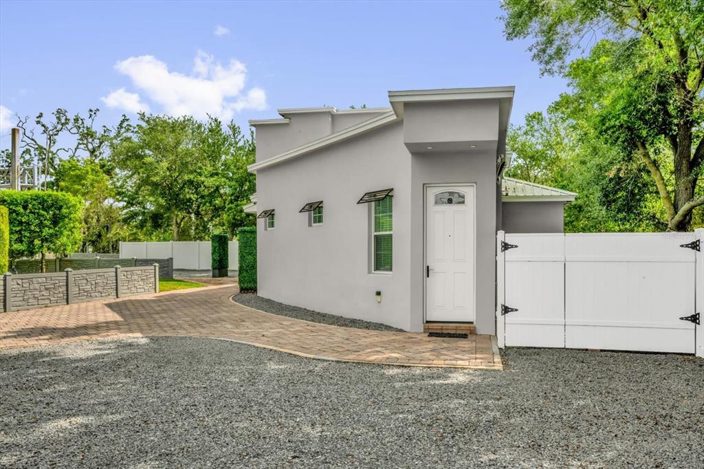 A gray exterior building with a white door sits next to a paved driveway — 726/720 N PENNSYLVANIA AVENUE, WINTER PARK, FL