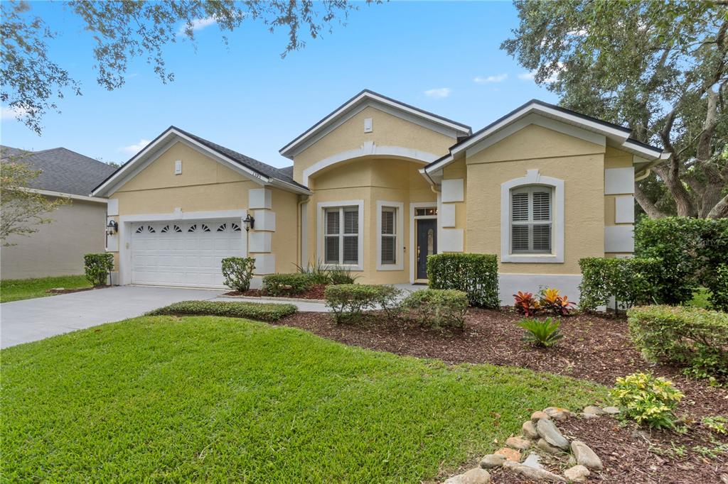 A single-story yellow house with a two-car garage and a landscaped front yard — 1393 STANFIELD COVE, LAKE MARY, FL