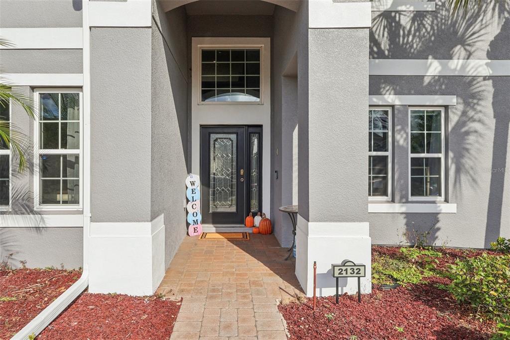 The exterior of a gray house features a brick walkway leading to a front door — 2132 PLANTATION OAK DR, ORLANDO, FL