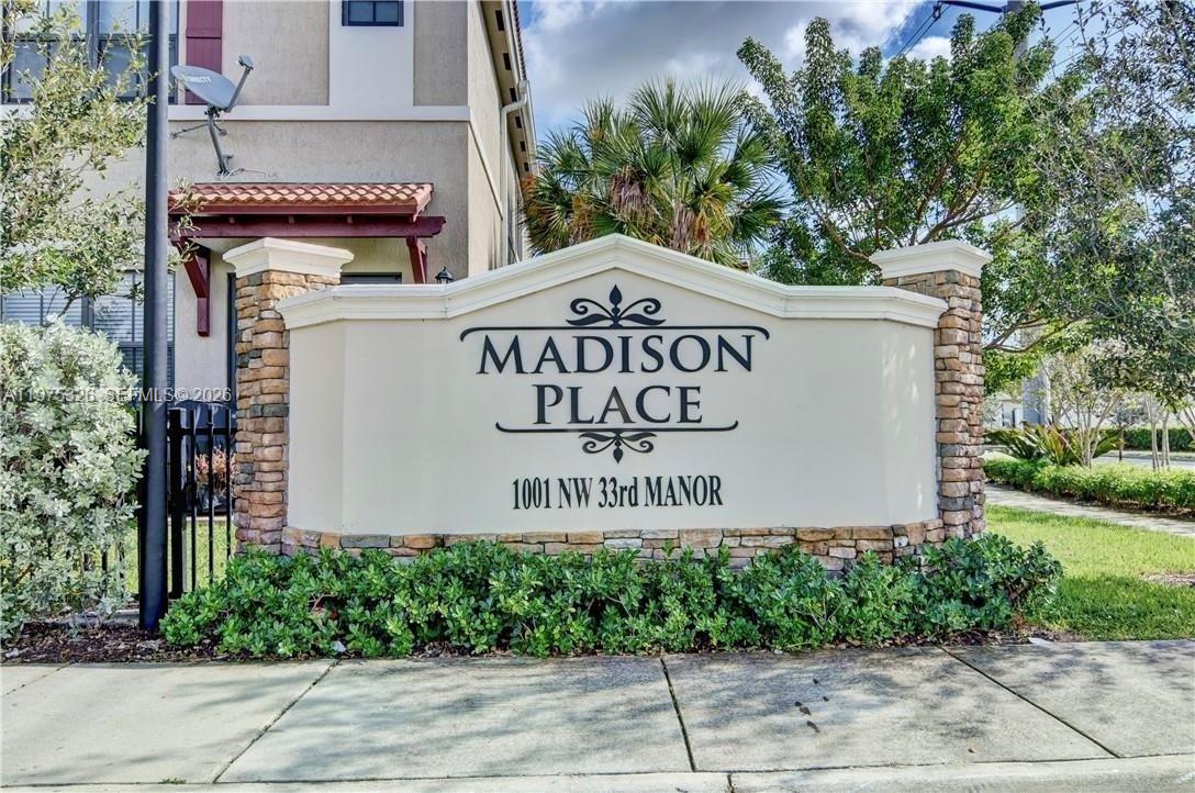 A stone and stucco monument sign displays the name of a residential community — 1071 NW 33rd Ct, Pompano Beach FL 33064, POMPANO BEACH, FL