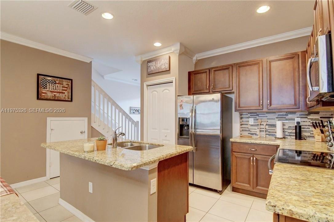A kitchen features granite countertops, stainless steel appliances, and dark wood cabinetry — 1071 NW 33rd Ct, Pompano Beach FL 33064, POMPANO BEACH, FL