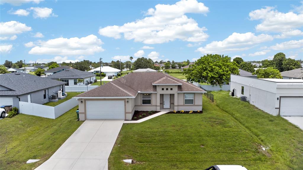 An aerial view of a single-story suburban house with a concrete driveway and lawn — 2714 NW 1ST PLACE, CAPE CORAL, FL
