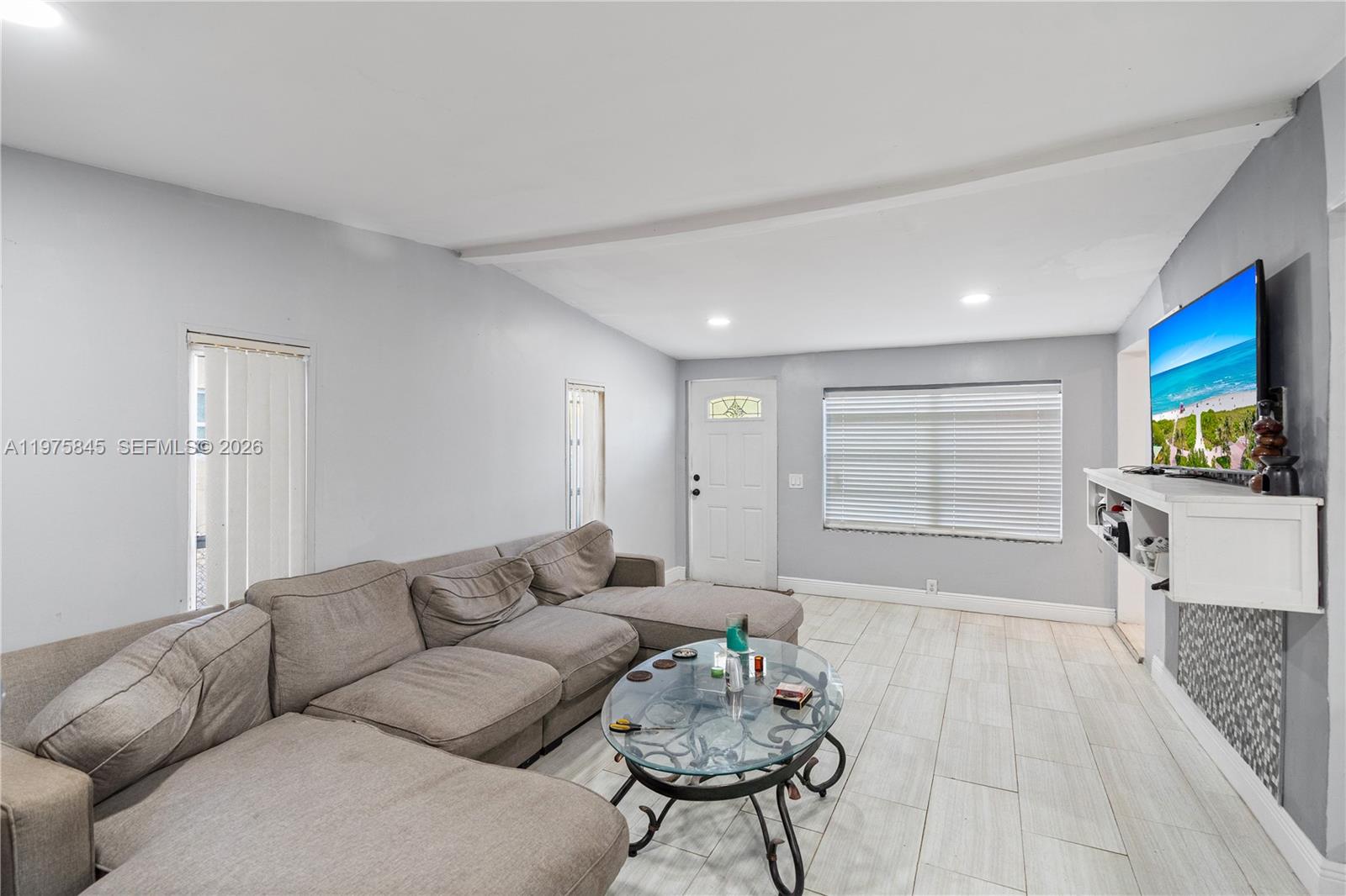 A living room features a grey sectional sofa, a glass coffee table, and a wall-mounted television — 4520 SW 38th St, West Park FL 33023, WEST PARK, FL