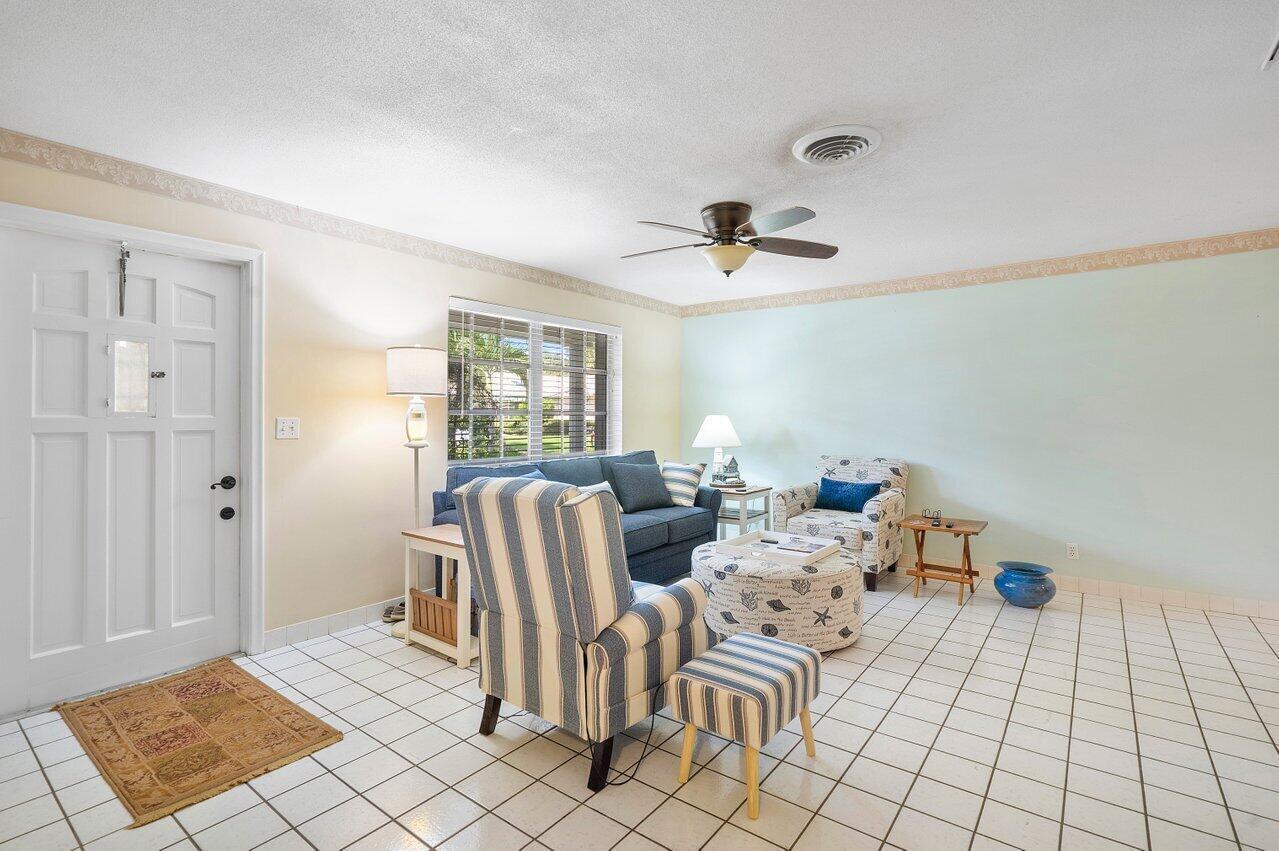 A living room features white tile floors, a striped armchair, and a blue sofa — 13 Sailfish Lane, Ocean Ridge FL 33435, OCEAN RIDGE, FL