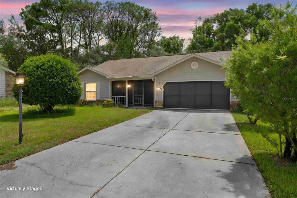 A single-story house with a concrete driveway, a screened porch, and a two-car garage — 2629 IMPERIAL PINE DRIVE, SPRING HILL, FL