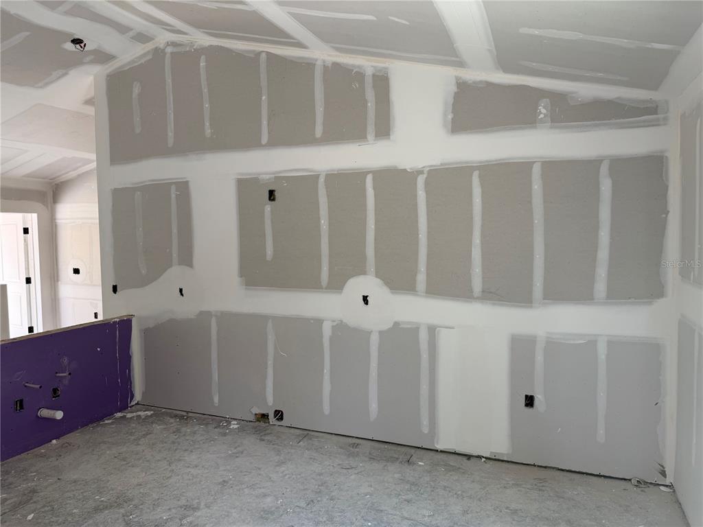 An unfinished room features walls with newly installed drywall and taped seams — 12227 MARYLAND AVENUE, PUNTA GORDA, FL