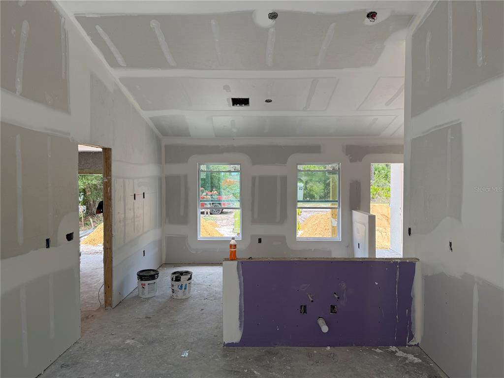 An unfinished room with drywall, a purple kitchen island base, and two windows — 12227 MARYLAND AVENUE, PUNTA GORDA, FL