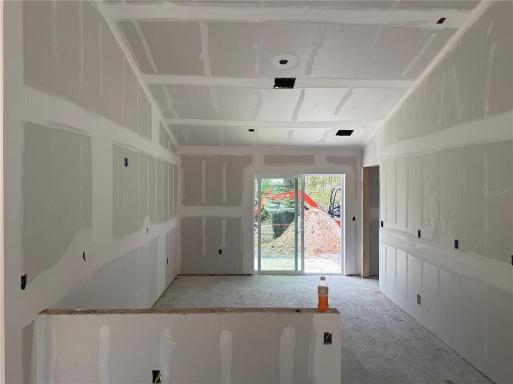 An unfinished room with drywall, a vaulted ceiling, and a sliding glass door to construction — 12227 MARYLAND AVENUE, PUNTA GORDA, FL