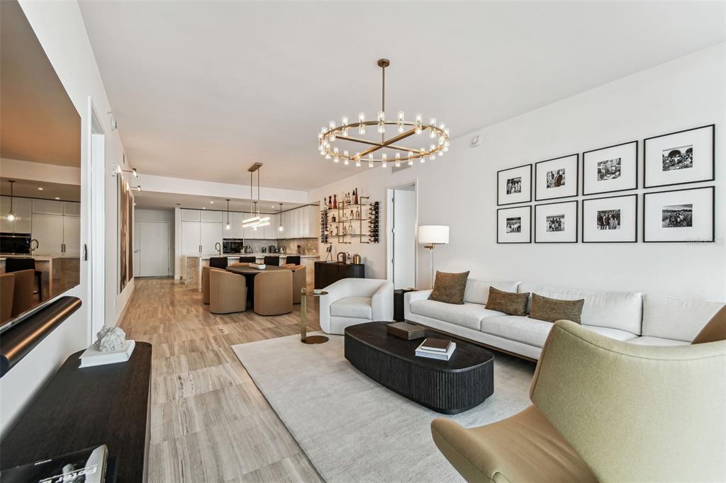 A modern open-concept living and dining area features white walls, tile floors, and a chandelier — 3101 BAYSHORE BOULEVARD UNIT 1402, TAMPA, FL