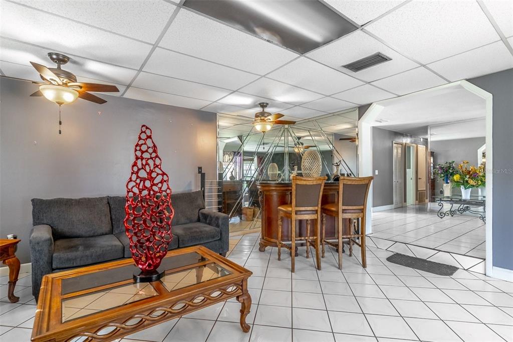 A living room features a grey sofa, a wooden coffee table, and a home bar — 3226 KELVINGTON DRIVE, ORLANDO, FL