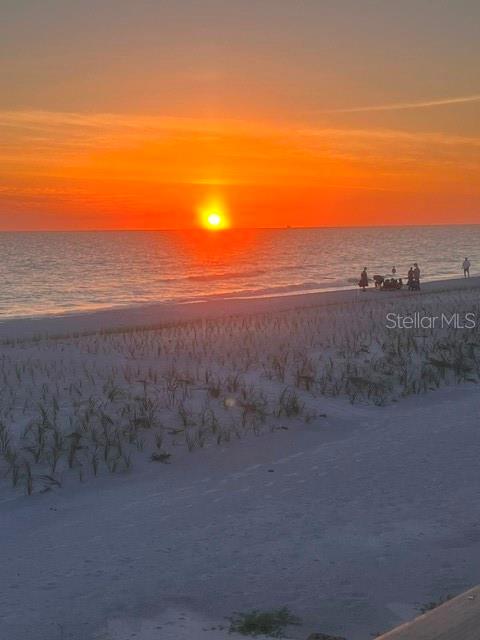 A view of a sunset over the ocean from a sandy beach with dunes — 8432 W GULF BOULEVARD UNIT Sailfish, TREASURE ISLAND, FL