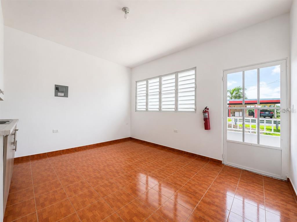 An empty room with orange tiled floors, white walls, louvered windows, and a glass door — CARR. 908 KM 9.4 BO. TEJAS APT. UNIT 7, HUMACAO, PR