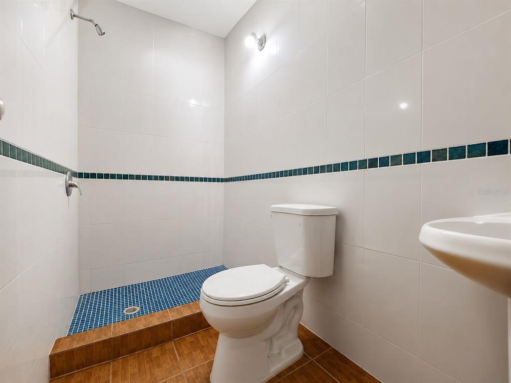 A bathroom features a tiled shower area, a white toilet, and light-colored wall tiles — CARR. 908 KM 9.4 BO. TEJAS APT. UNIT 7, HUMACAO, PR
