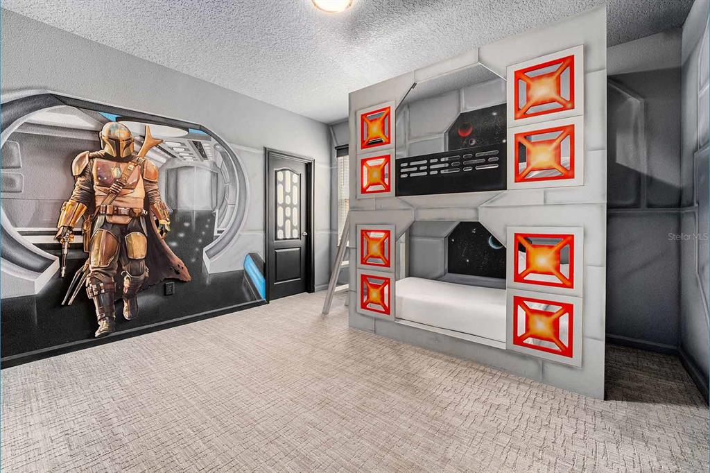 A Star Wars-themed bedroom features a Mandalorian wall mural and a custom spaceship bunk bed — 8013 OAK SHADOW COURT, DAVENPORT, FL