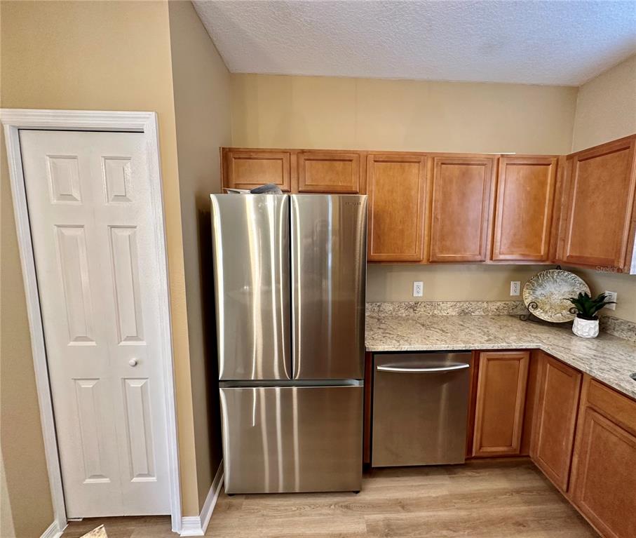 A kitchen features stainless steel appliances, wood cabinets, and granite countertops — 12276 COUNTRY WHITE CIRCLE, TAMPA, FL