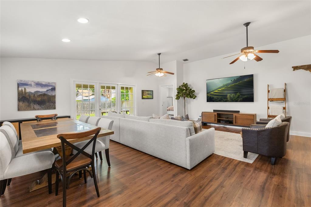 A living and dining room with wood floors, a large sectional, and a wall-mounted television — 21 E YALE STREET, ORLANDO, FL