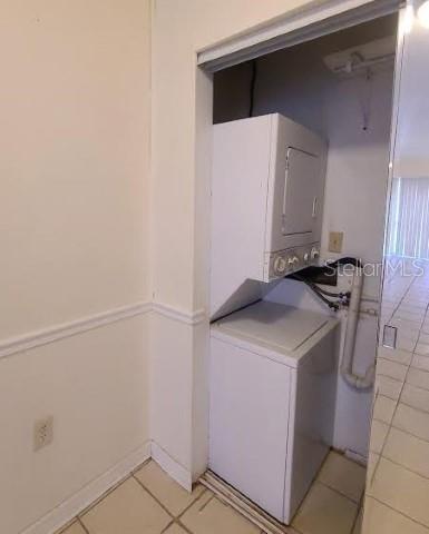 A white stacked washer and dryer unit sits in a small tiled laundry closet — 8602 HURON COURT UNIT 50, TAMPA, FL