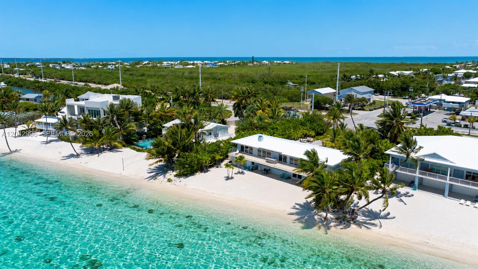 An aerial view shows beachfront houses with white roofs, palm trees, and turquoise water — 74051 Overseas Hwy, Islamorada FL 33036, ISLAMORADA, FL