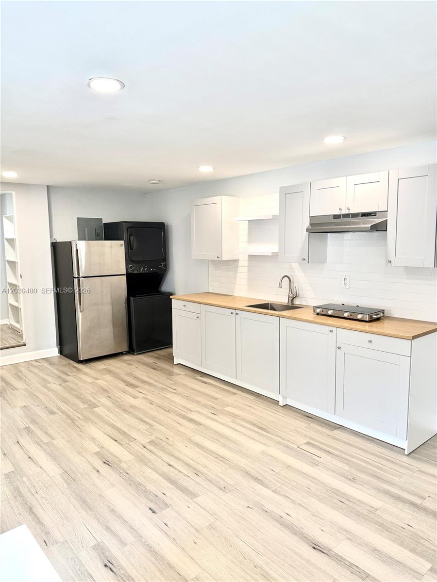 A kitchen features light gray cabinets, a wood countertop, stainless steel appliances, and wood flooring — 227 SW 26th Rd Rear, Miami FL 33129, MIAMI, FL