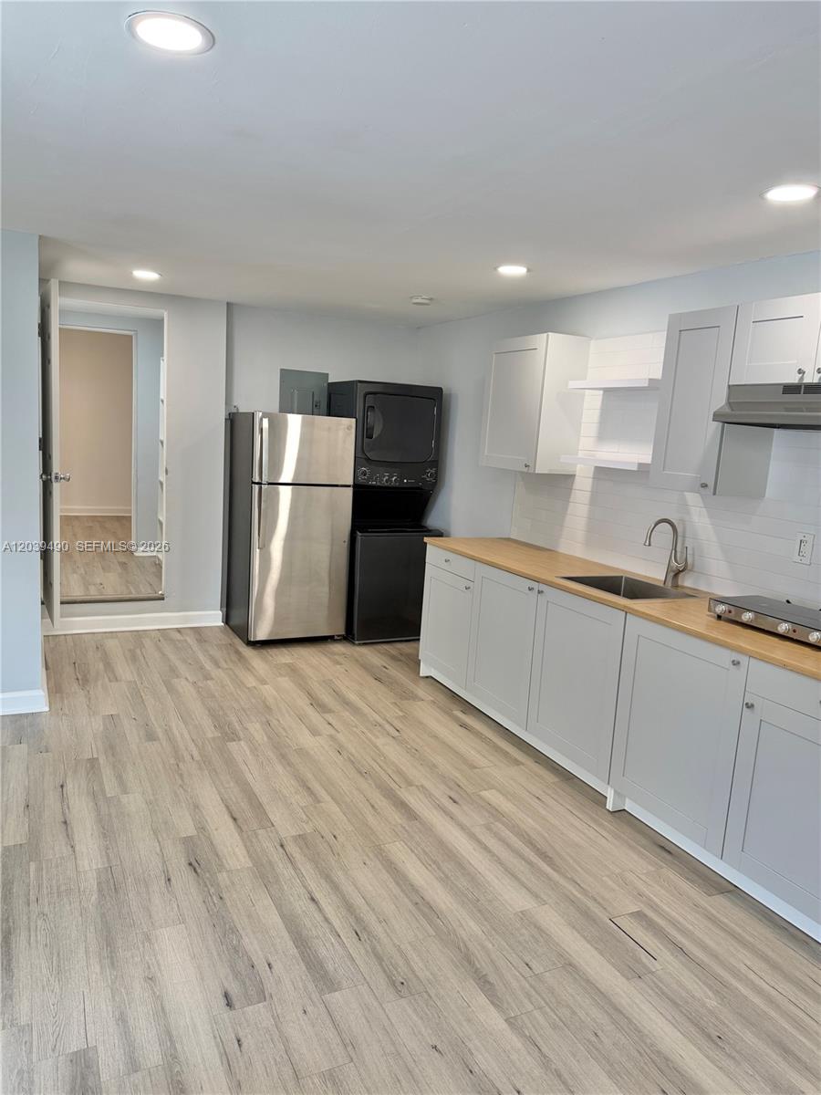 A kitchen features light gray cabinets, a wood countertop, stainless steel appliances, and wood-look flooring — 227 SW 26th Rd Rear, Miami FL 33129, MIAMI, FL