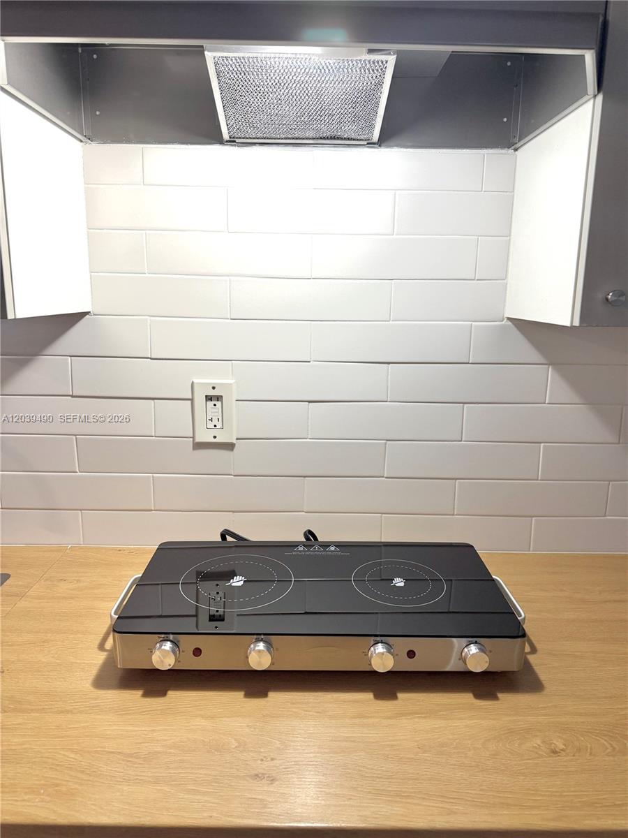A portable double burner cooktop sits on a wooden countertop against a white backsplash — 227 SW 26th Rd Rear, Miami FL 33129, MIAMI, FL