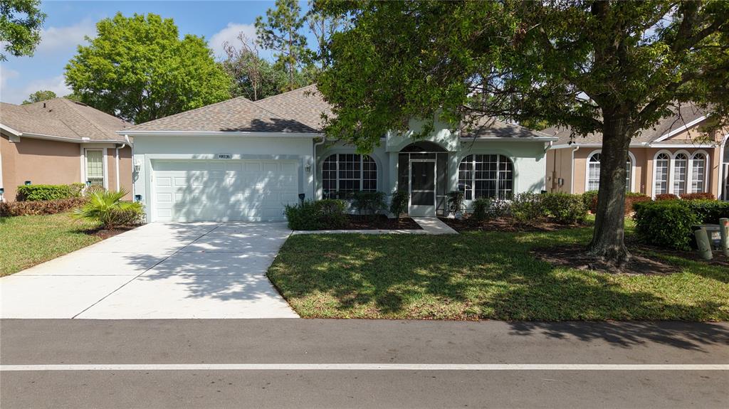 A single-story house with a two-car garage, arched windows, and a front lawn — 2282 FENTON AVENUE, CLERMONT, FL