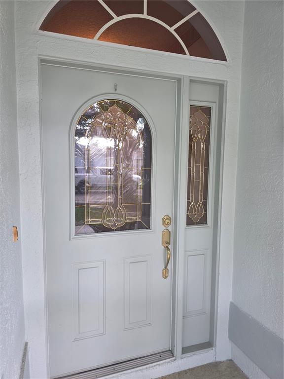 A light gray front door with a decorative glass insert and a matching side light — 2282 FENTON AVENUE, CLERMONT, FL