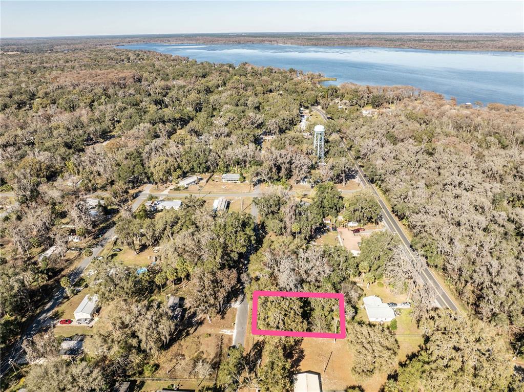 An aerial view shows a wooded residential lot highlighted by a pink rectangle near water — 000 CR 422, LAKE PANASOFFKEE, FL