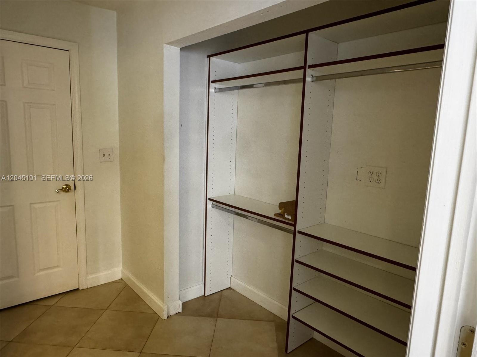A walk-in closet features white shelving, hanging rods, and a wall-mounted electrical outlet — 158 SW 96th Ct # B, Miami FL 33174, MIAMI, FL