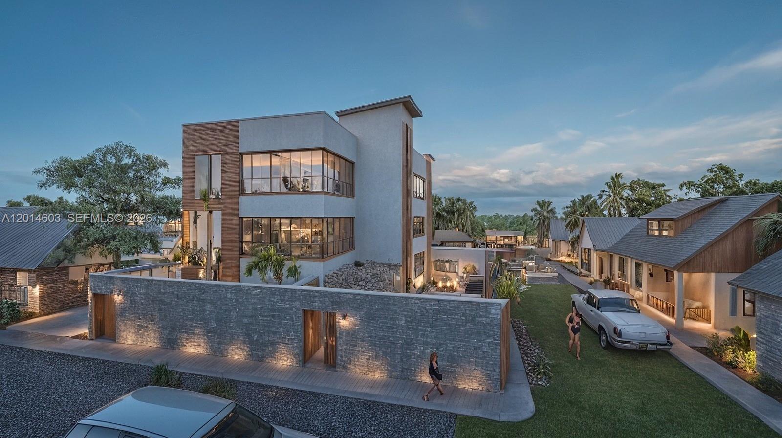 This architectural rendering shows a modern multi-story home with a stone wall and surrounding buildings — Near Blvd del Coral & Av.Barcelo # 0, FL