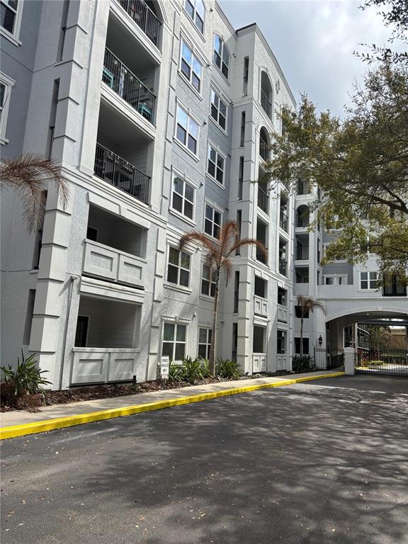 A multi-story apartment building with balconies and a gated entrance under a bridge — 300 E SOUTH STREET UNIT 6004, ORLANDO, FL