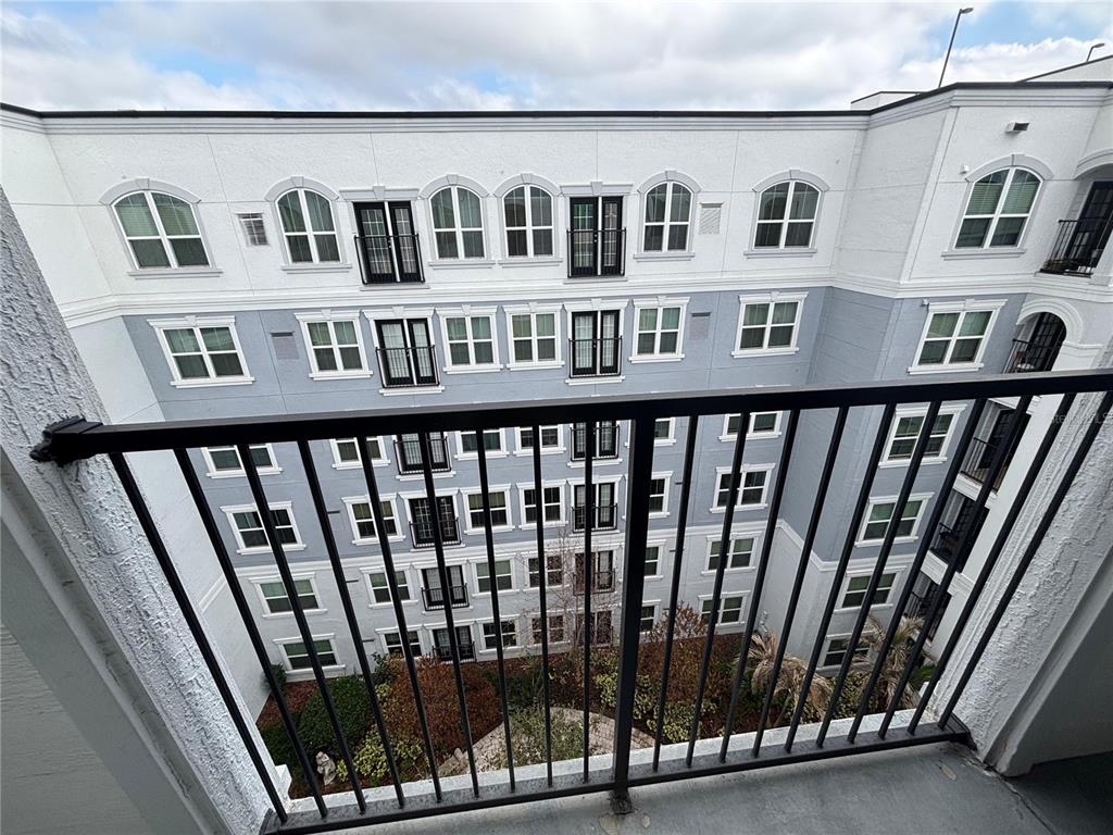 A view from a balcony overlooking a multi-story apartment building courtyard — 300 E SOUTH STREET UNIT 6004, ORLANDO, FL