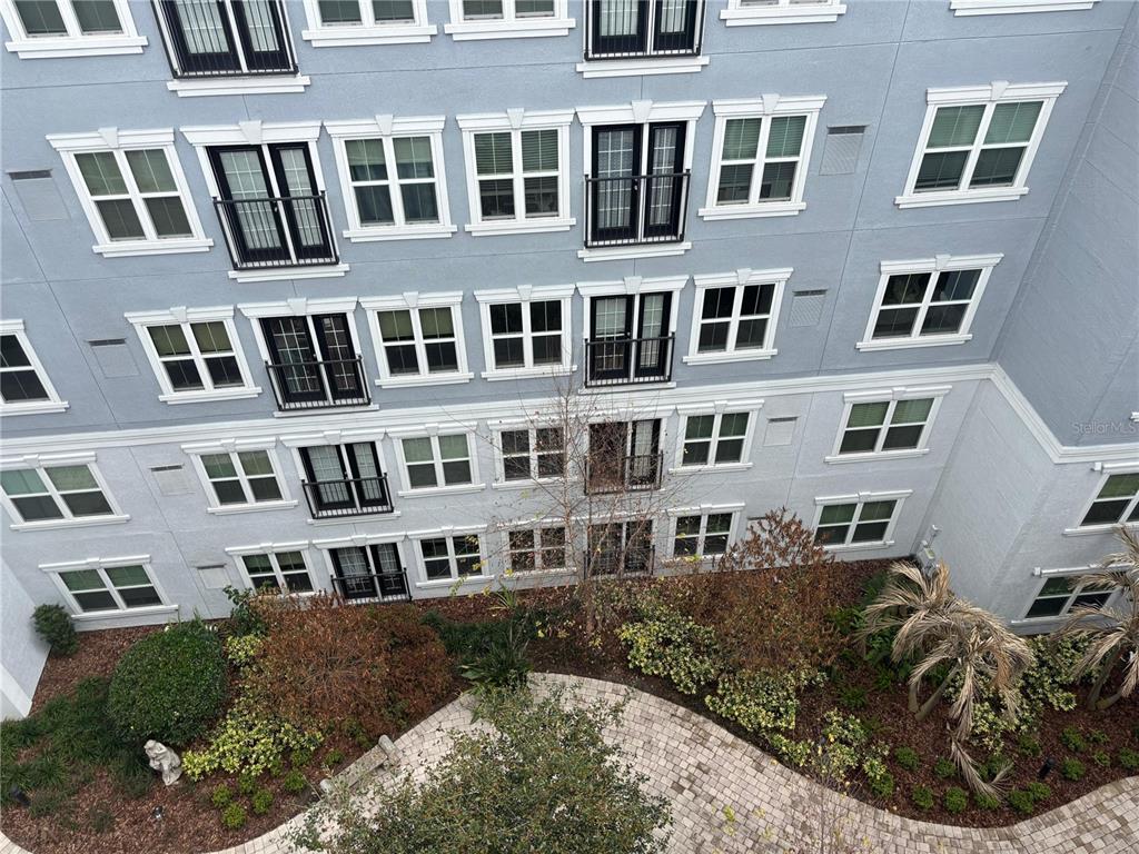 An elevated view of a multi-story apartment building exterior with balconies and a landscaped courtyard — 300 E SOUTH STREET UNIT 6004, ORLANDO, FL