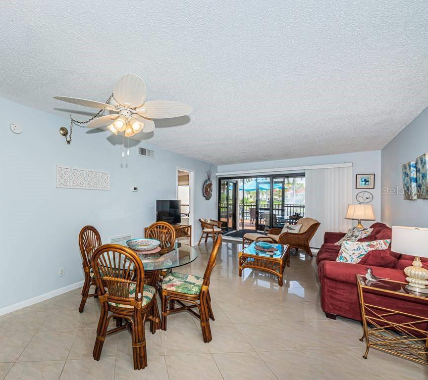 A living and dining room with tile floors, a ceiling fan, and a sliding glass door — 6294 BAHIA DEL MAR CIRCLE UNIT 114, ST PETERSBURG, FL