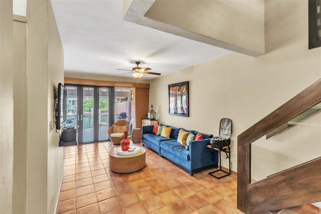 A living room with tile floors, a blue sofa, and glass doors leading to a patio — 7 ISLA SAN MARCOS UNIT 7, HUMACAO, PR