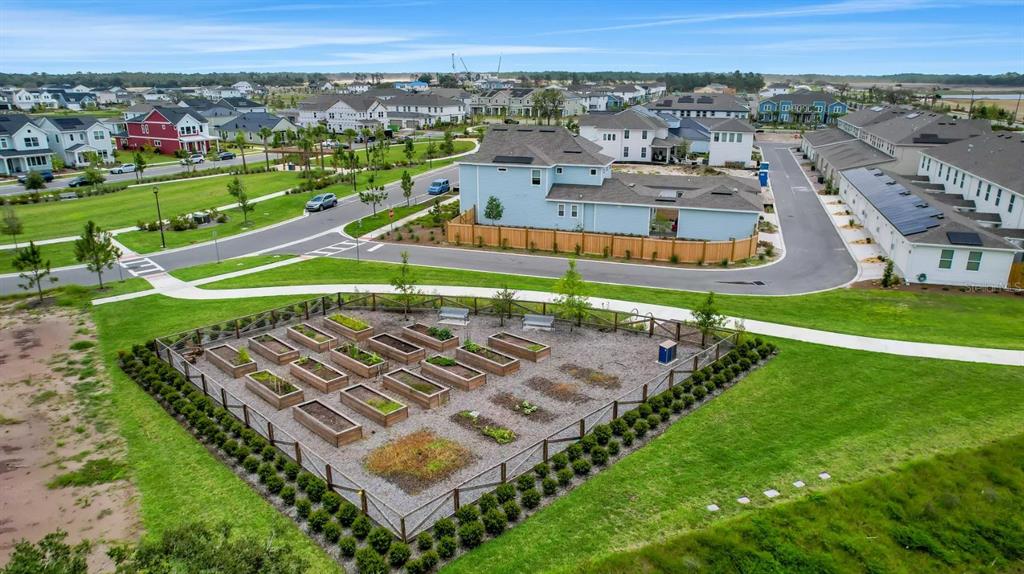 An aerial view shows a community garden with raised beds surrounded by a suburban neighborhood — 2984 GARDEN TRAIL BEND, ST CLOUD, FL
