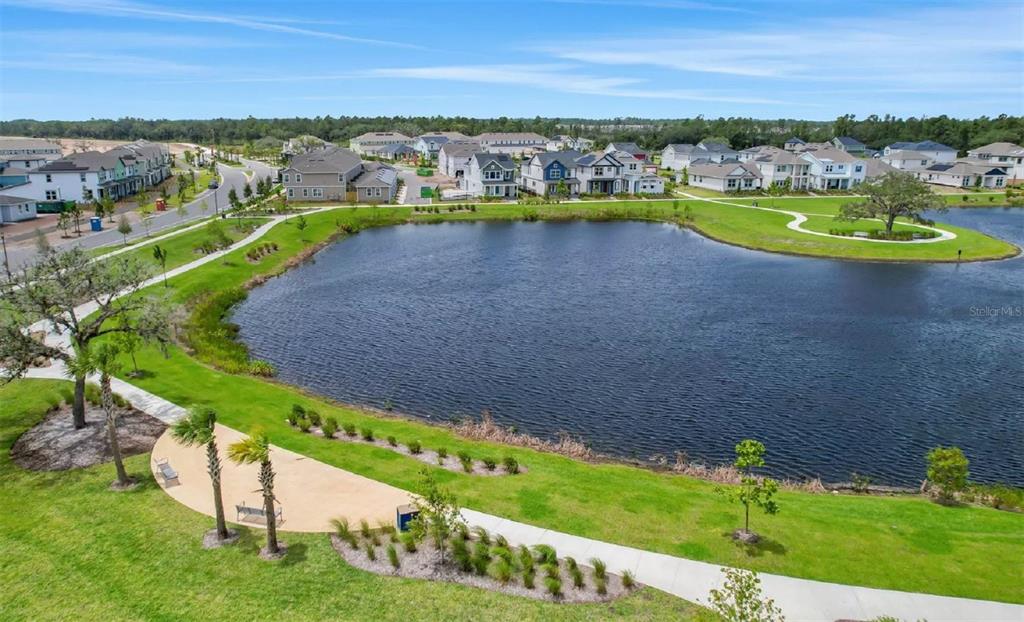 An aerial view shows a pond surrounded by a walking path and residential houses — 2984 GARDEN TRAIL BEND, ST CLOUD, FL