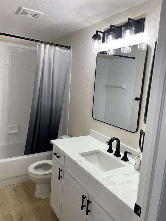 A bathroom features a white vanity with a black faucet, a mirror, and a shower-tub combo — 10467 HALLMARK BOULEVARD, RIVERVIEW, FL