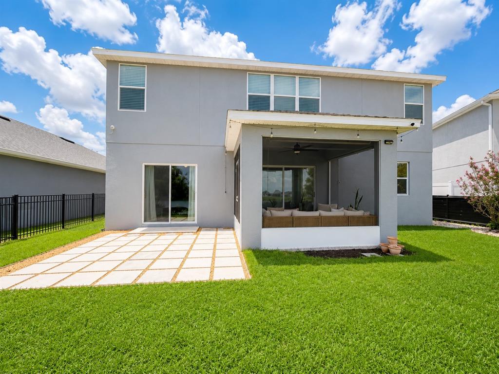The exterior of a two-story house features a screened-in patio and a paved stone patio — 5267 WHITE EGRET LANE, LAKELAND, FL