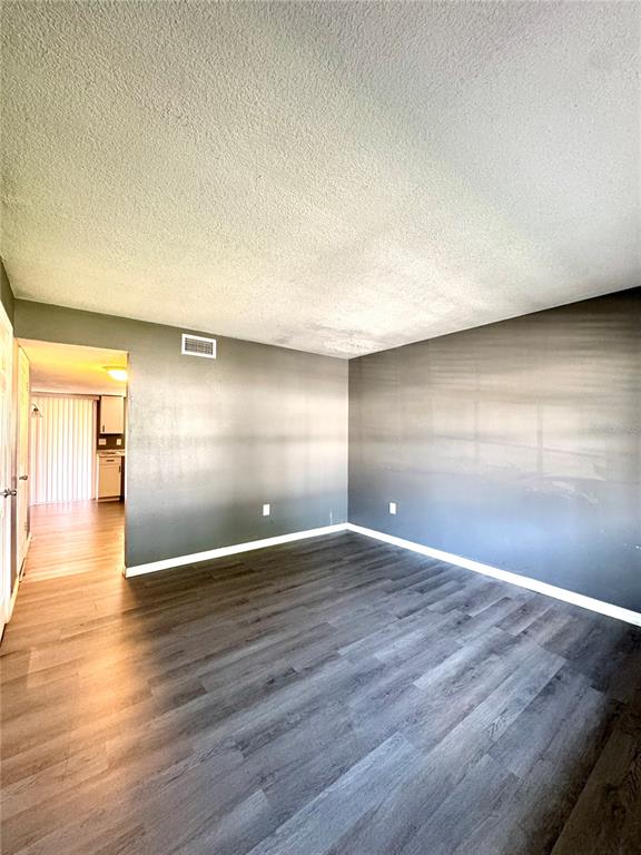 A room with dark gray walls, wood-look flooring, and a white textured ceiling — 1415 RIDGE LAKE COURT, LAKELAND, FL