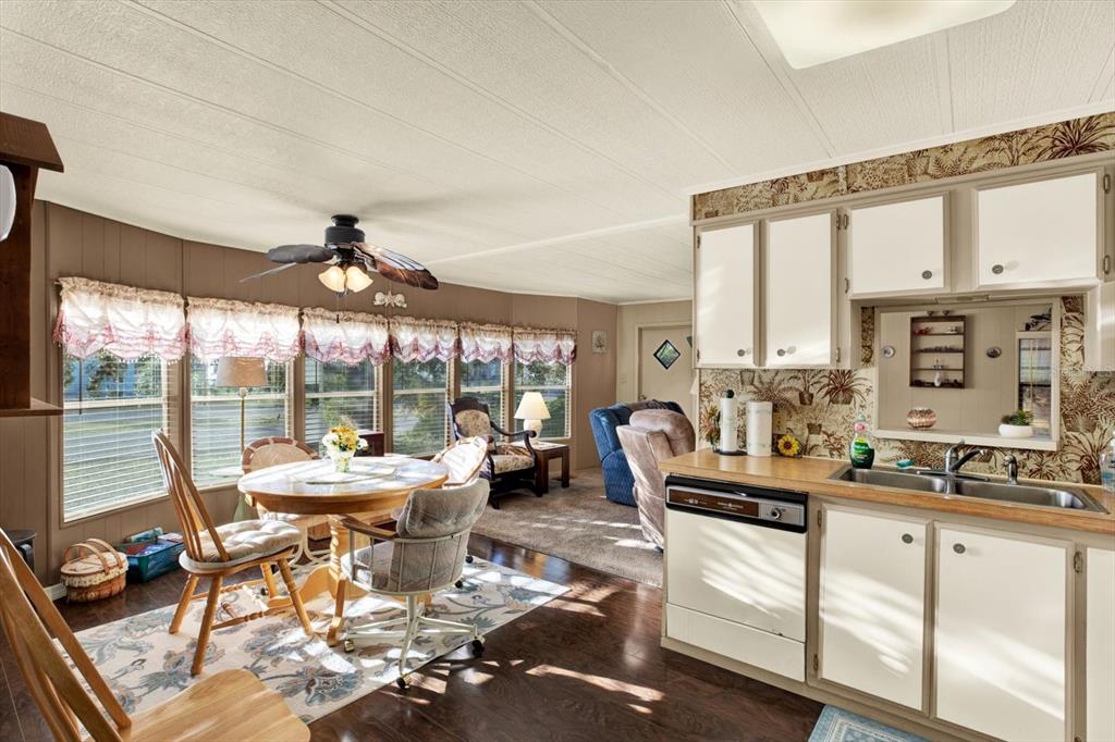 A kitchen and dining area with wood flooring, floral wallpaper, and a ceiling fan — 14294 BROOKRIDGE BOULEVARD, BROOKSVILLE, FL