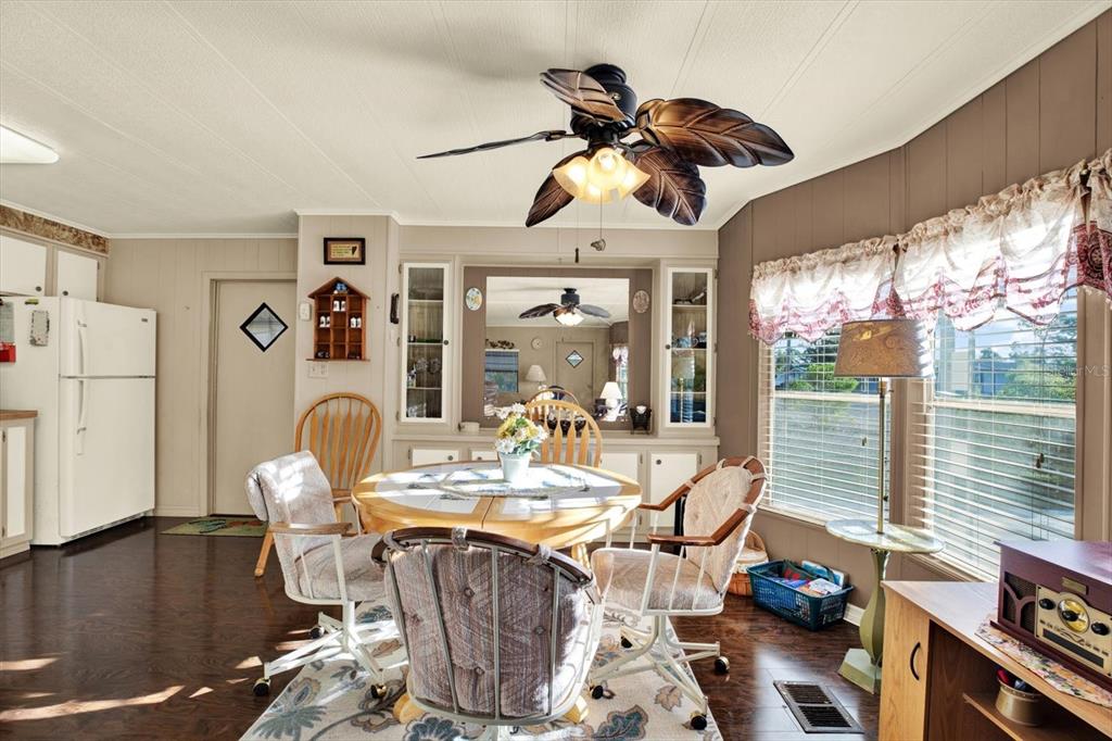 A dining area features a round table, four chairs, a ceiling fan, and a mirror — 14294 BROOKRIDGE BOULEVARD, BROOKSVILLE, FL