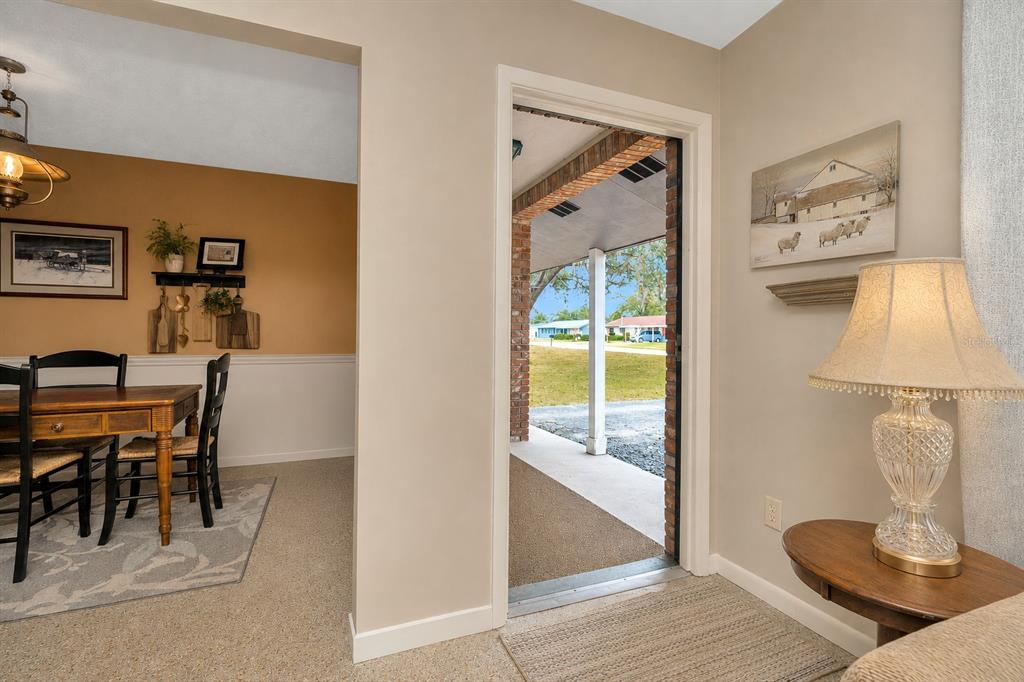 A view from an interior room looking through an open doorway toward a covered porch — 12212 FLORAL LANE, THONOTOSASSA, FL