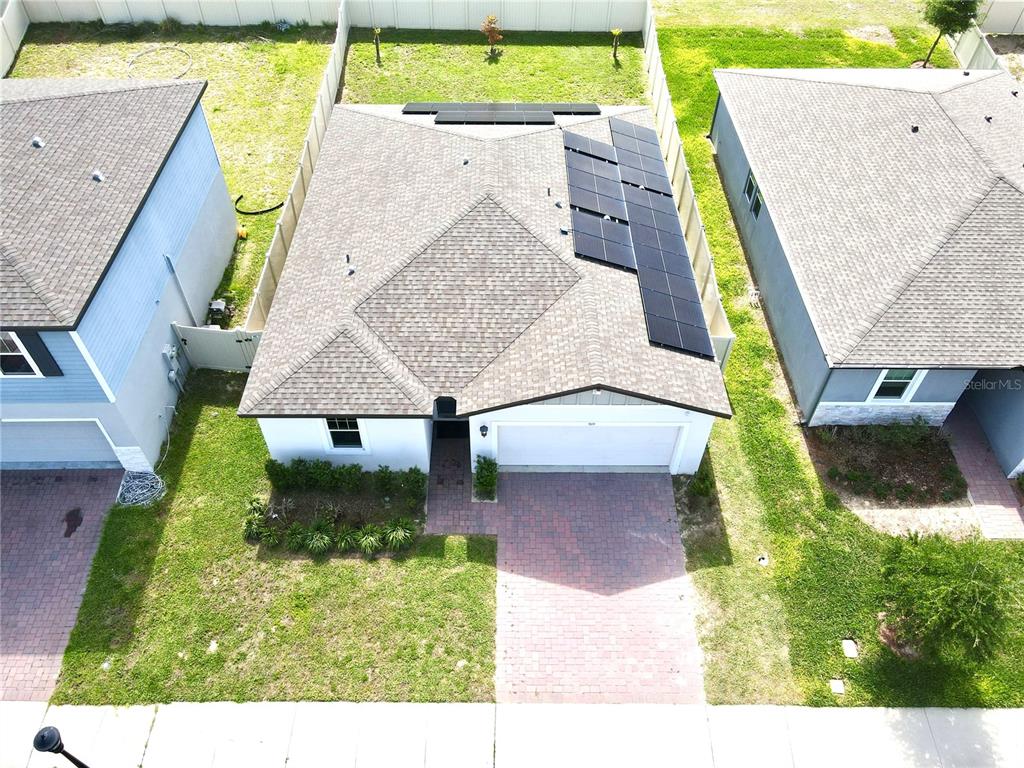 An aerial view of a single-family home with solar panels on the roof — 909 CAMBRIDGE DRIVE, WINTER HAVEN, FL