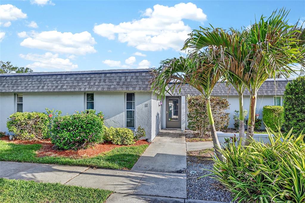 A single-story house with a gray exterior, a shingled roof, and a palm tree out front — 4160 FRUITVILLE ROAD UNIT 11, SARASOTA, FL
