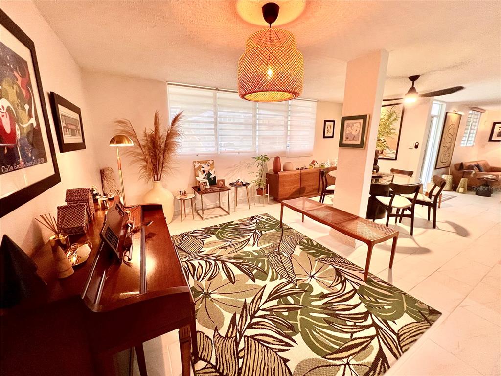 A living room features a patterned area rug, a piano, and a woven pendant light — B8 CALLE 8 LAGO URB ALTAMIRA, FAJARDO, PR