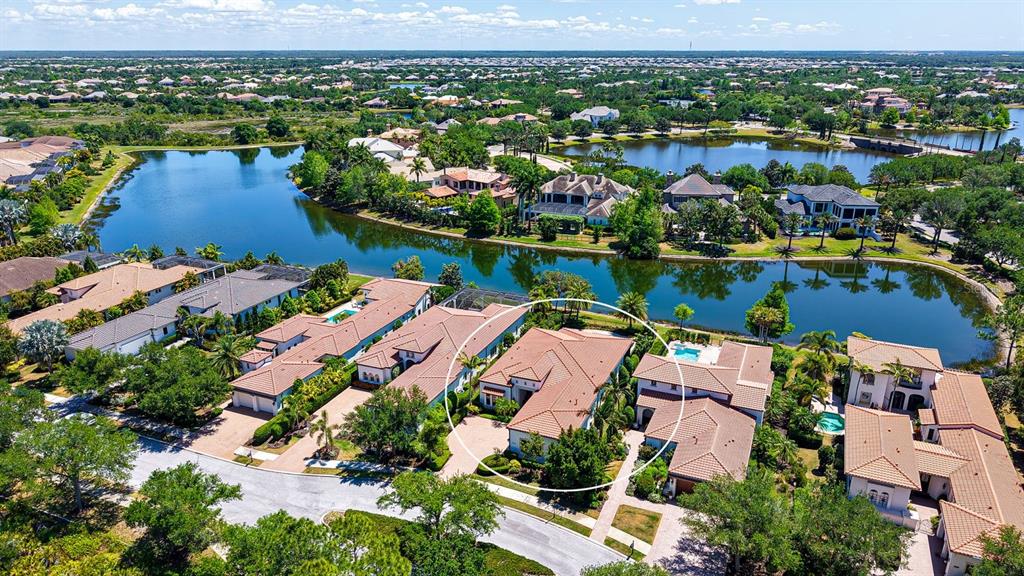 An aerial view shows a residential neighborhood with a circled house near a lake — 7975 MATERA COURT, LAKEWOOD RANCH, FL