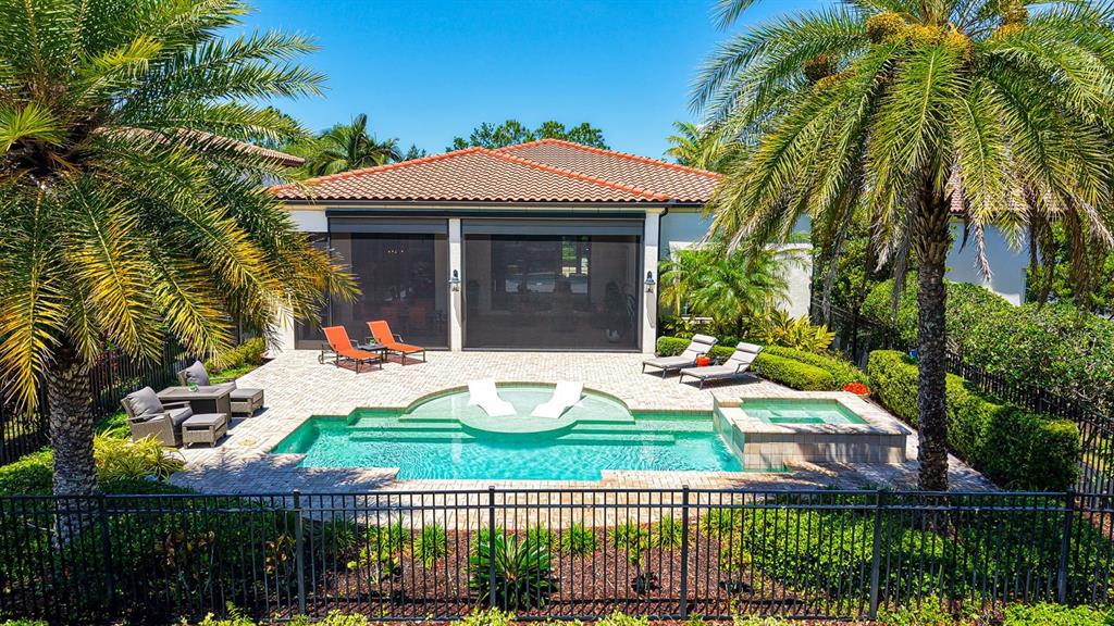 An outdoor patio features a swimming pool with a spa and lounge chairs — 7975 MATERA COURT, LAKEWOOD RANCH, FL