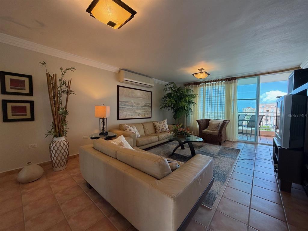 A living room features beige leather sofas, tile flooring, and a balcony with ocean views — PR3 CARR. PUERTO DEL REY UNIT PC2, CEIBA, PR